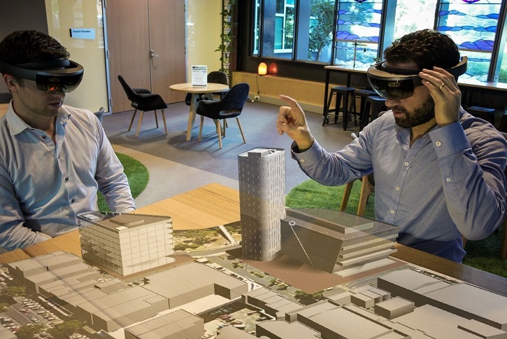 Two men wearing HoloLenses gazing at 3D VR model of Werribee City Centre