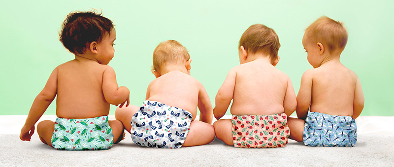 A rear view of four babies wearing nappies